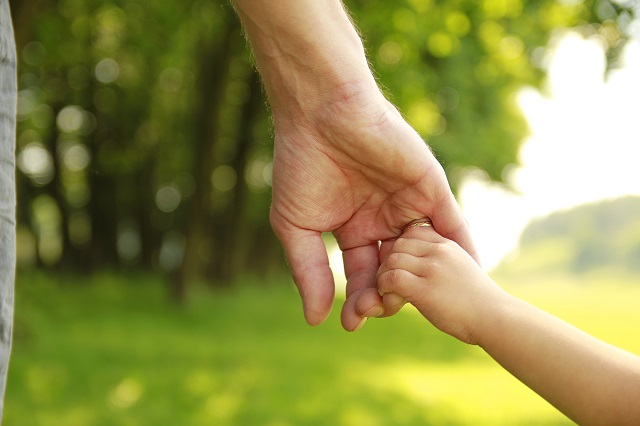 Adult and child holding hands to symbolize adopting a Child In California